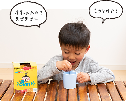 画像：マグカップに入れた「とけた！」をスプーンで混ぜる穂くん「牛乳に入れてまぜまぜ〜」