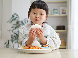 写真：おにぎりを食べる依璃ちゃん