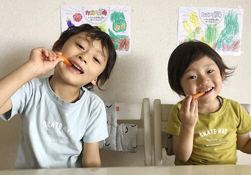 写真：笑顔で野菜を食べる二人