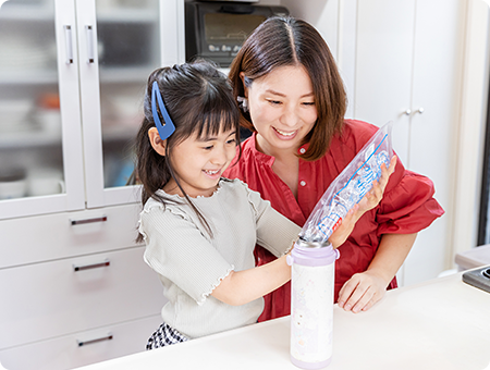 写真:水筒に氷を入れる縁ちゃん（6歳）と奈央子さん